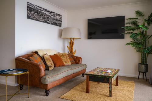 uma sala de estar com um sofá e uma televisão em Beyond The Sea - FREE all Island parking permit em Ventnor