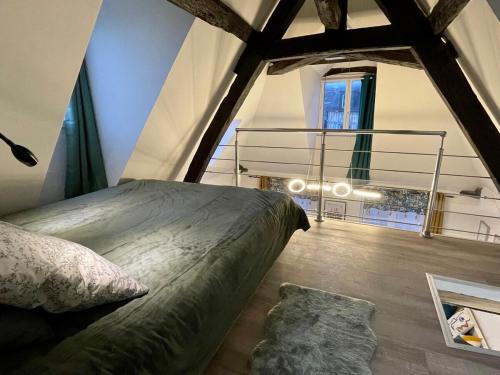une chambre avec un grand lit dans un grenier dans l'établissement Le 1731, Rouen coeur d'histoire, superbe duplex, à Rouen