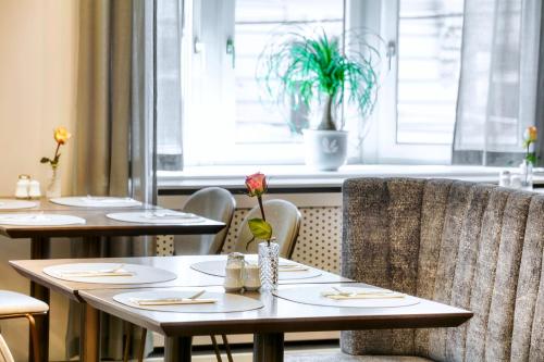 a restaurant with tables and chairs and a window at Hotel City Central in Vienna