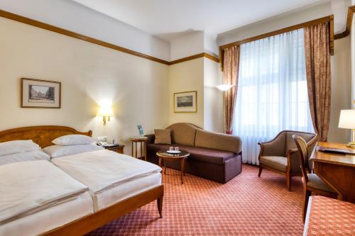 une chambre d'hôtel avec un lit, un canapé et une chaise dans l'établissement Hotel City Central, à Vienne