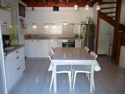 een keuken met een witte tafel en witte apparaten bij Maison mitoyenne jardin piscine tennis in Hendaye