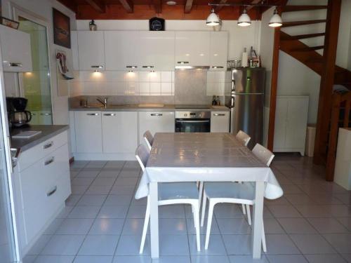 a kitchen with a white table and white appliances at Maison mitoyenne jardin piscine tennis in Hendaye