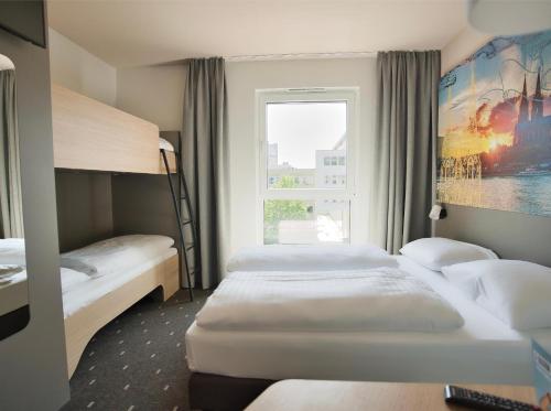 科隆的住宿－B&B Hotel Köln-City，酒店客房设有三张床和窗户。