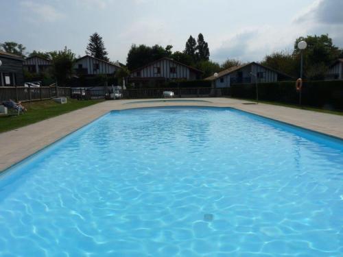 een groot blauw zwembad in een tuin bij Maison mitoyenne jardin piscine tennis in Hendaye