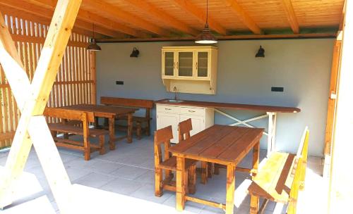 eine Küche mit Holztischen und -stühlen auf einer Terrasse in der Unterkunft Stylový vesnický apartmán v soukromí M. Skála Český Ráj in Koberovy
