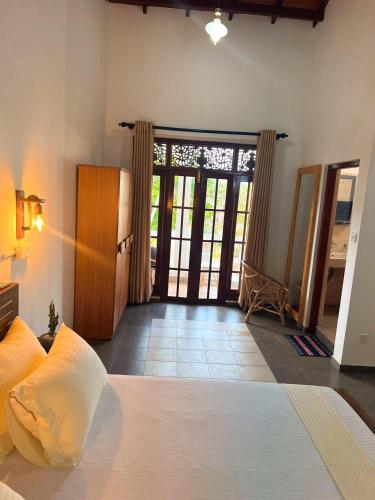 a bedroom with a bed and a sliding glass door at Hummus Hostel Hikkaduwa in Hikkaduwa