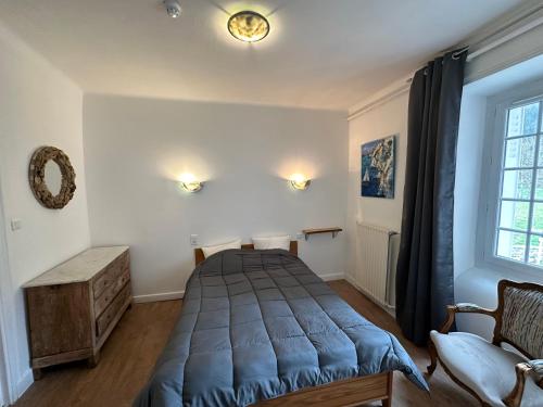 a bedroom with a bed and a chair and a window at HL Hotel de la Loire in Goudet