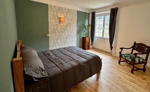 um quarto com uma cama, uma cadeira e uma janela em HL Hotel de la Loire em Goudet