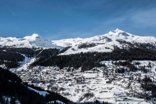 a ski resort in the mountains with snow at Hôtel Alpina - Swiss Ski & Bike Lodge Grimentz in Grimentz