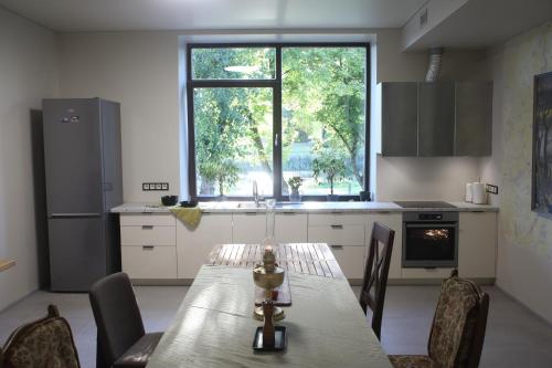 a kitchen with a table with chairs and a window at VEPA in Vepriai
