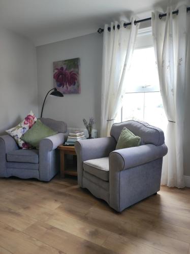 a living room with two couches and a window at Apartments at Ballinsheen House & Gardens in Lisdoonvarna