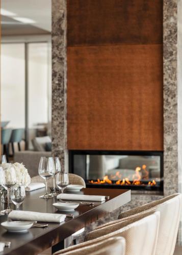 a dining table with a fireplace in a restaurant at One&Only Portonovi in Herceg-Novi