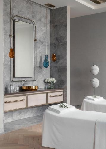 a bathroom with two white tables and a mirror at One&Only Portonovi in Herceg-Novi