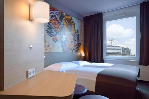 ein Hotelzimmer mit einem Bett und einem Fenster in der Unterkunft B&B Hotel Köln-Ehrenfeld in Köln