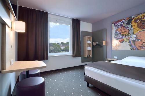 a hotel room with a bed and a window at B&B Hotel Köln-Ehrenfeld in Cologne