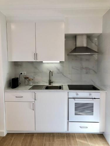 a white kitchen with white cabinets and a sink at Casa Martins Country Apartment No5 in Freiria