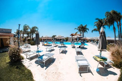 a pool with lounge chairs and umbrellas at Egò Salento in Galatina