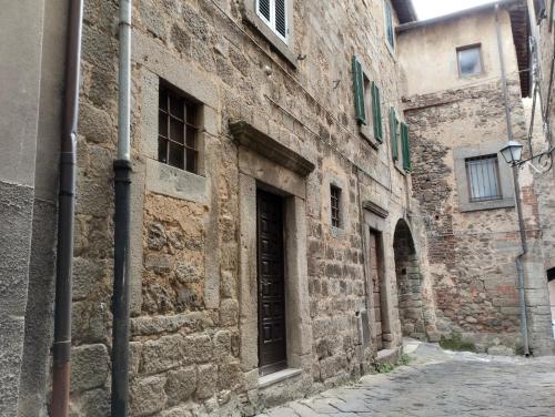 an alley in an old stone building with a door at Casa della chiocciola in Castel del Piano