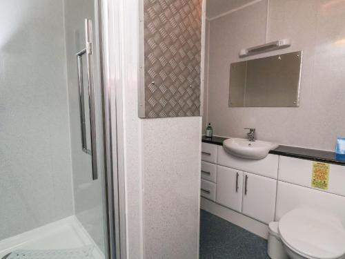 ein weißes Bad mit einem Waschbecken und einem WC in der Unterkunft Acorns in Holywell