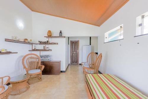 グアラジュバにあるGB19 Casa 7 Quartos a 50m da Praia - Guarajubaの椅子、テーブル、冷蔵庫が備わる客室です。