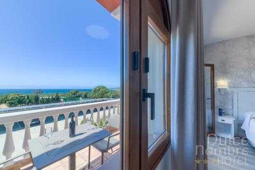 a room with a balcony with a view of the ocean at Dulce Nombre Hotel - Apartamentos in Tarifa