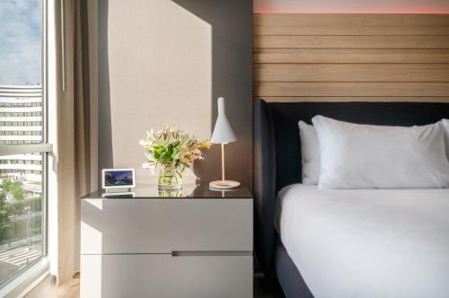 a bedroom with a bed and a table with a vase of flowers at Hotel Zena Washington DC in Washington