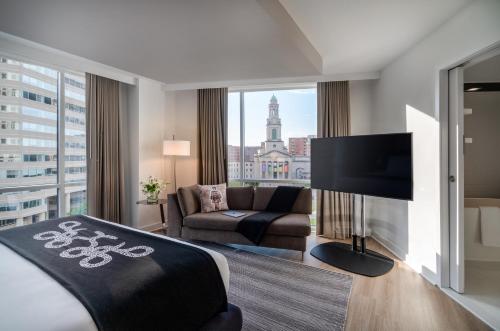 a hotel room with a bed and a couch and a tv at Hotel Zena Washington DC in Washington