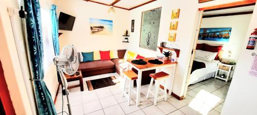 una pequeña sala de estar con sofá y mesa. en Cape Cozy Cottages en Ciudad del Cabo