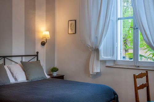 1 dormitorio con cama y ventana en Villa Liberty Urbino, en Urbino