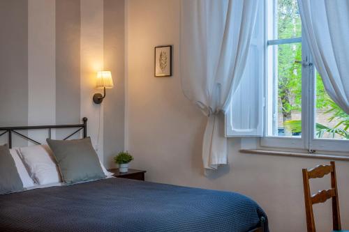 a bedroom with a bed and a window at Villa Liberty Urbino in Urbino