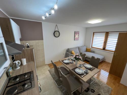 a kitchen and living room with a table and a couch at Kuća za odmor Saturnus in Karanac