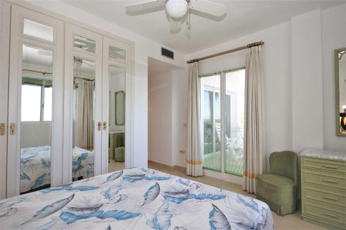 1 dormitorio con 1 cama, vestidor y ventanas en Apartment GENOA, en Estepona