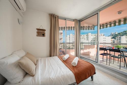 a bedroom with a bed and a large window at Appartement 4 pers à 50m de la plage, avec piscine in Roquebrune-Cap-Martin