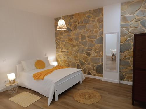 a bedroom with a bed and a stone wall at Kings B&B Santa Cruz in Santa Cruz