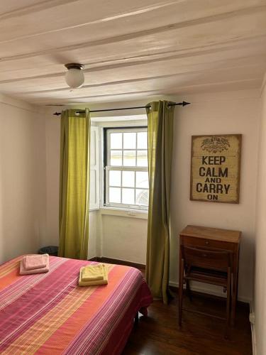een slaapkamer met een bed, een raam en een tafel bij Bairro Alto Flat in Lissabon