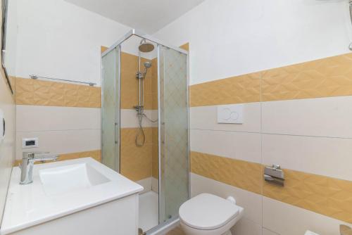 uma casa de banho com um lavatório, um WC e um chuveiro em Monolocale grande em La Maddalena