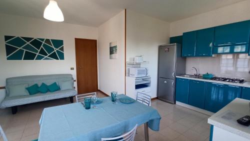 eine Küche mit blauen Schränken und einem Tisch im Zimmer in der Unterkunft New Piccolo Residence in Malcesine