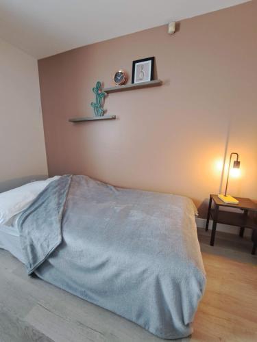 a bedroom with a bed and a table with a lamp at Habitations Zenith in Sainte-Anne-de-Beaupré