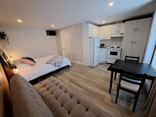 a bedroom with a bed and a table and a kitchen at Habitations Zenith in Sainte-Anne-de-Beaupré