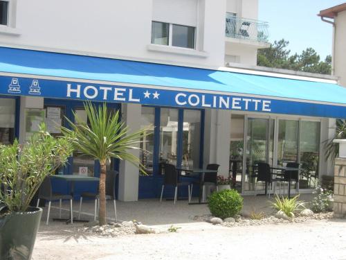 een hotelgebouw met tafels en stoelen ervoor bij Hotel Colinette in Saint-Georges-de-Didonne