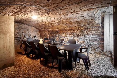 une salle à manger avec des tables et des chaises et un mur en briques dans l'établissement Le wine studio Gevrey-Chambertin, à Gevrey-Chambertin