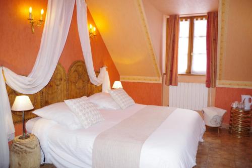 - une chambre avec un grand lit et des draps blancs dans l'établissement LA LAUZERAIE, à La Bourboule