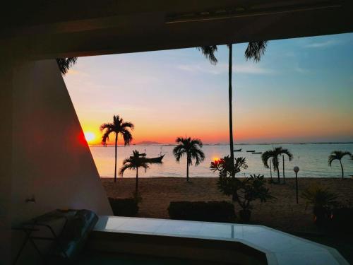 a view of the beach at sunset from a house at มารินอส บีชเฮ้าส์ Marinos Beach house in Si Racha