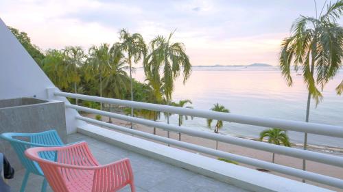 a balcony with two chairs and a view of the ocean at มารินอส บีชเฮ้าส์ Marinos Beach house in Si Racha
