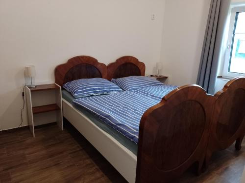 a bed with wooden headboards in a bedroom at Penzion Litohlavy 17 - Na samotě u lesa in Králŭv Dvŭr
