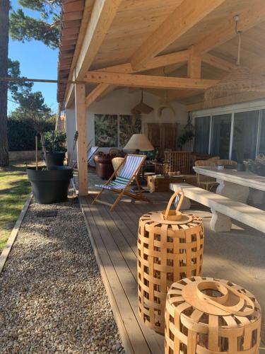 a wooden deck with a picnic table and chairs at Maison "LA ROSALINDA-2B" Ghisonaccia in Ghisonaccia