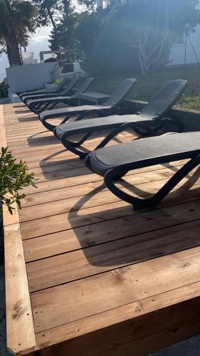 a row of lounge chairs lined up on a wooden deck at Maison "LA ROSALINDA-2B" Ghisonaccia in Ghisonaccia