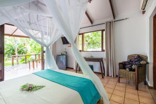 a bedroom with a bed with a mosquito net at LEMON BEACH LODGE Vilankulo in Vilanculos