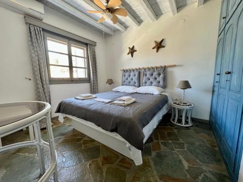 a bedroom with a bed and a ceiling fan at The Traditional Stone Villa in Koundouros