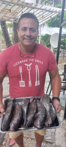 a man is holding a tray of fish at Riviera Punta Cana Eco Travelers in Punta Cana